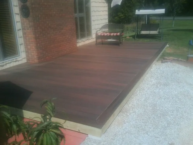 Freshly stained wood deck built against a brick home in Hartly