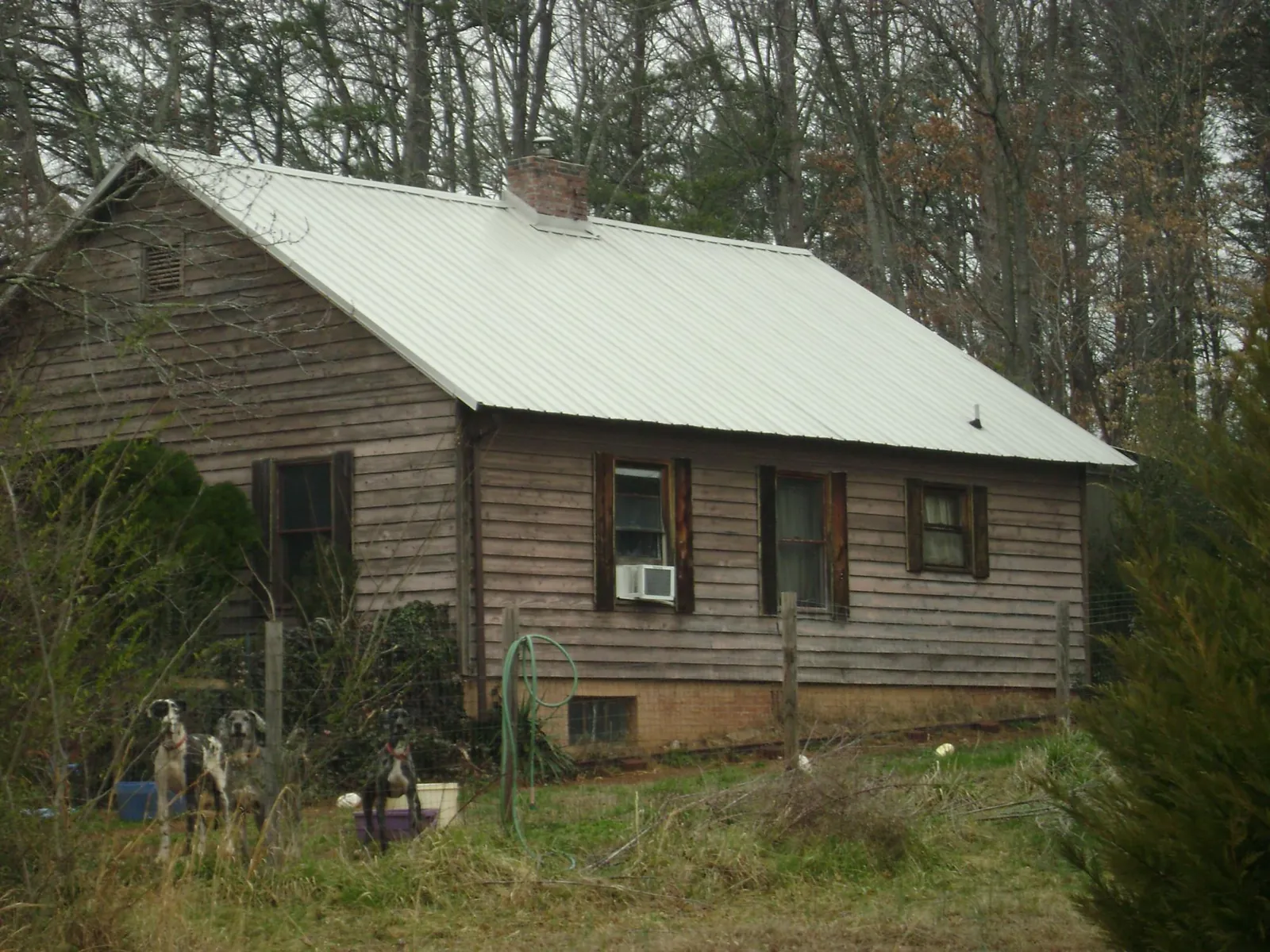 White metal roof on an old wood sided farmhouse, from a Metal Roof Installation job in Hartly